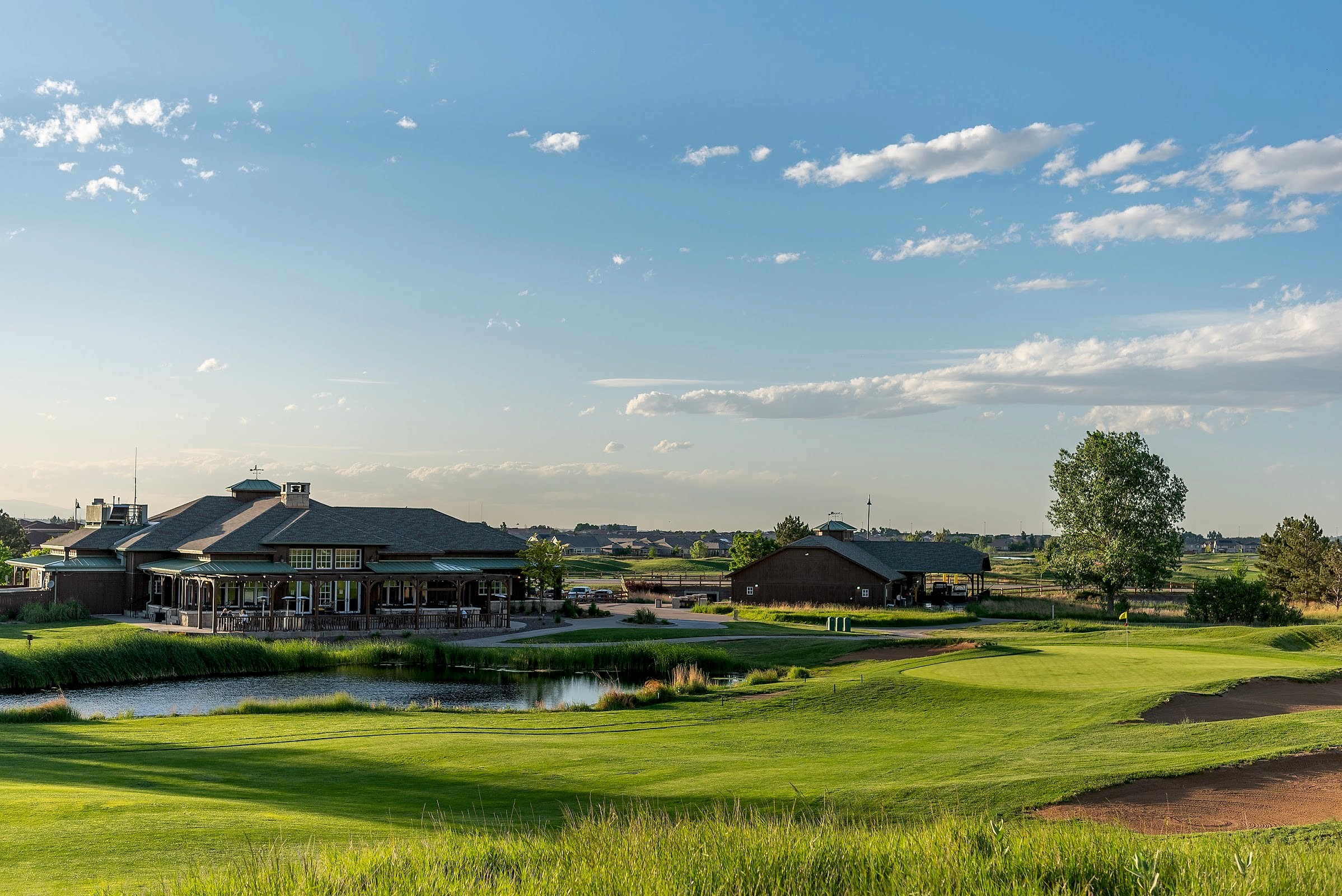 Buffalo Run clubhouse with water hazard and Colorado sky
